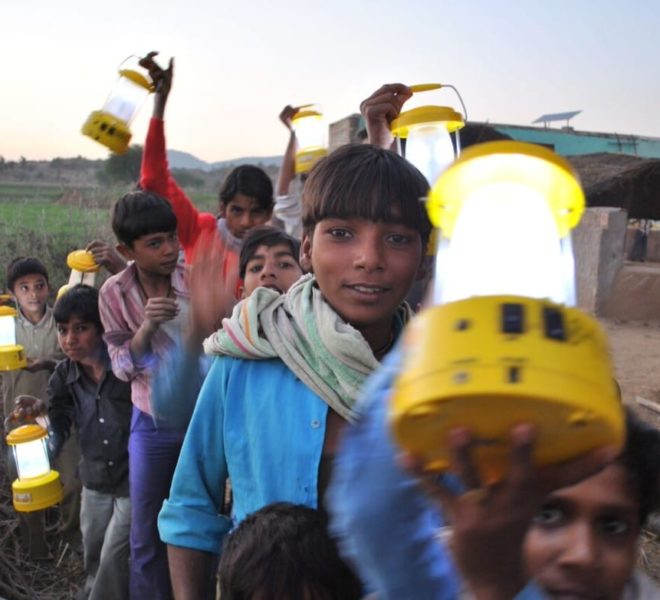 children holding up yellow electric lanterns