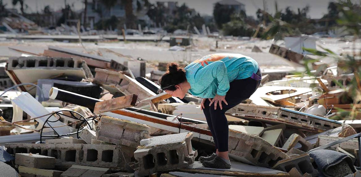 Woman looking through the rubble left after Hurricane Michael