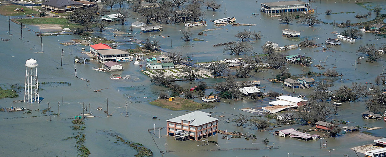 Floodwaters enveloping homes, roads, and trees